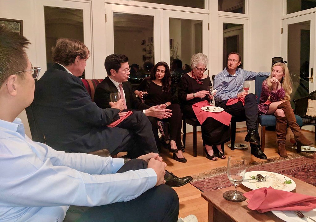 A writer working at a desk with a laptop displaying AI-assisted writing software, surrounded by traditional note-taking tools.