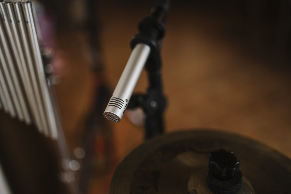 Modern music production workspace with studio monitors, headphones, and computer displaying audio software